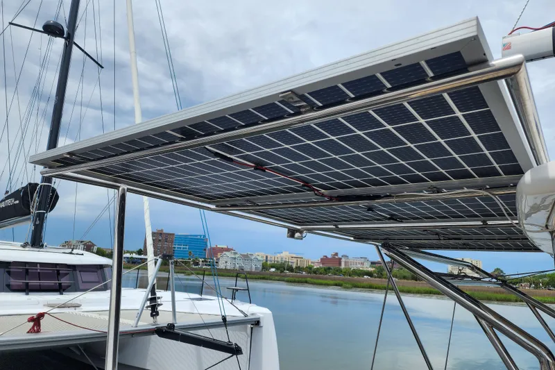 Slide: The Image of Solar panels on a 2020 Leopard 45 catamaran, docked by a scenic waterfront. - 13