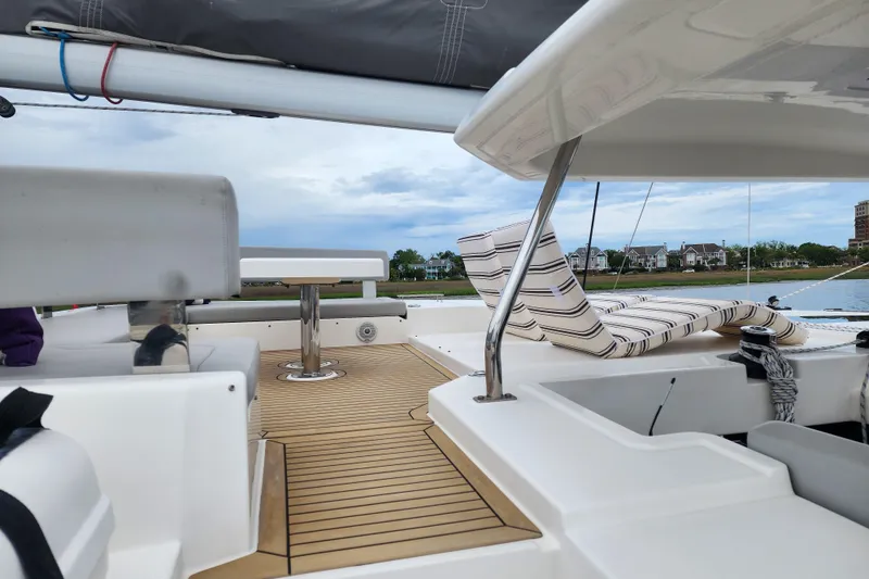 Slide: The Image of Luxurious 2020 Leopard 45 catamaran deck with seating and scenic waterfront view. - 18