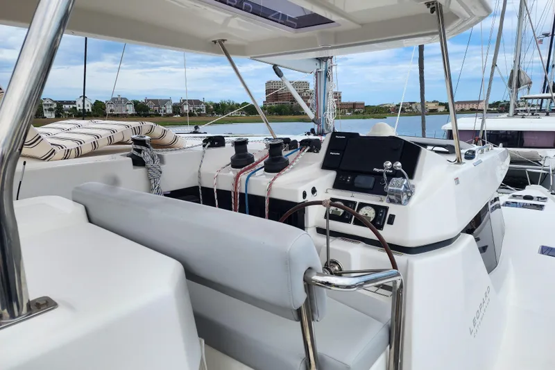 Slide: The Image of Leopard 45 catamaran helm station with modern controls, docked near waterfront homes. - 19
