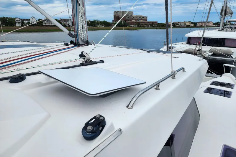 Slide: The Image of 2020 Leopard 45 catamaran with sleek deck design, docked by a scenic waterfront. - 39