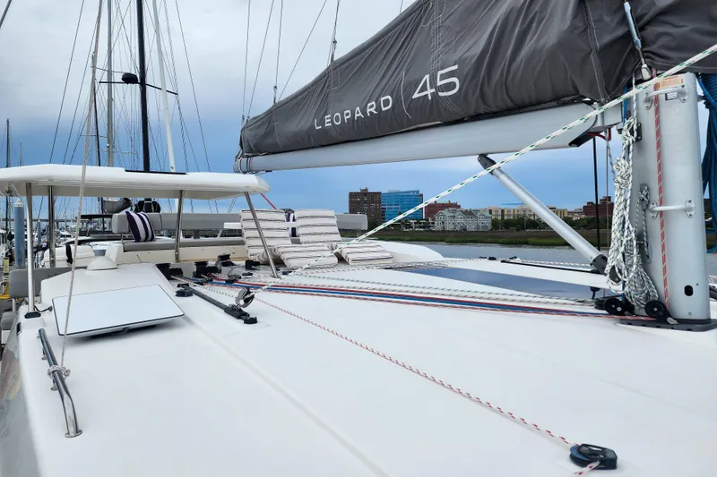 Slide: The Image of 2020 Leopard 45 catamaran deck with sails, docked in a marina. - 41