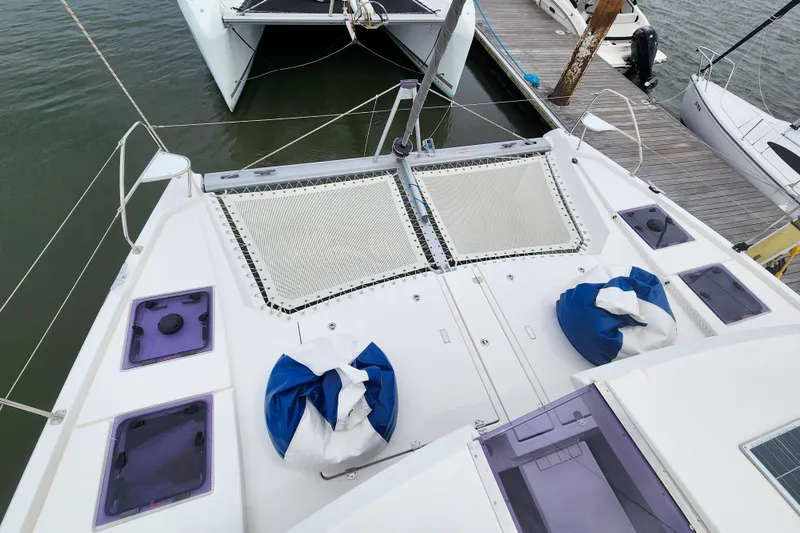 Slide: The Image of Leopard 45 catamaran deck with netting and blue cushions, docked at marina, 2020 model. - 46