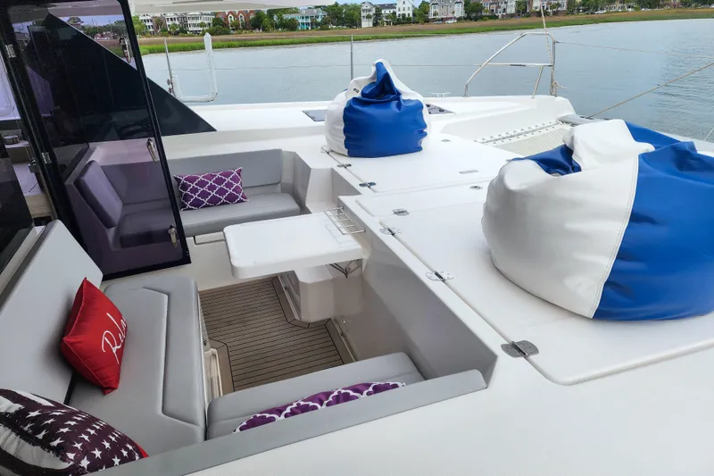 Slide: The Image of Luxurious 2020 Leopard 45 yacht deck with seating, bean bags, and scenic waterfront view. - 54