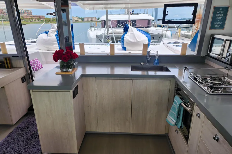 Slide: The Image of Modern kitchen interior on a 2020 Leopard 45 catamaran, featuring sleek countertops and nautical views. - 70