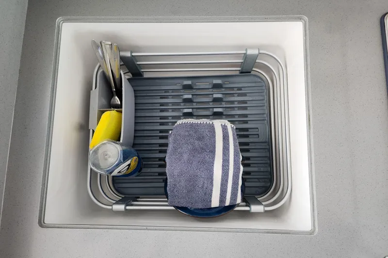 Slide: The Image of Kitchen sink with utensils, sponge, and towel in a drying rack, Leopard 45 model, 2020. - 73