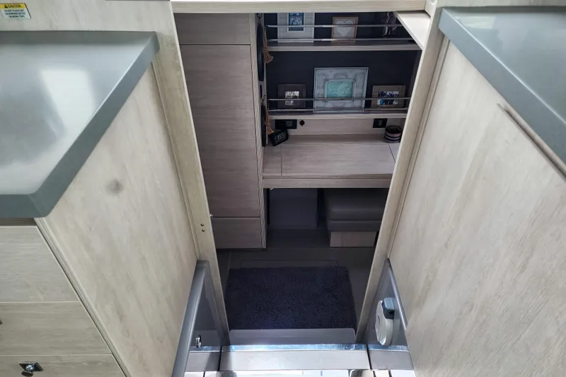 Slide: The Image of Modern interior of a 2020 Leopard 45 catamaran, featuring sleek wood finishes and organized storage. - 82