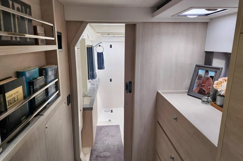 Slide: The Image of Modern Leopard 45 yacht interior with books, framed photo, and bathroom view. - 87