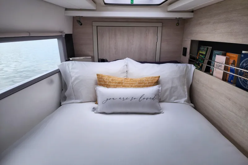 Slide: The Image of Cozy bedroom in a 2020 Leopard 45 yacht with pillows and books. - 97