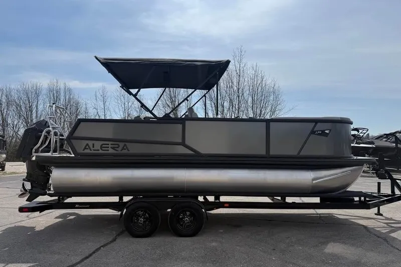The Image of 2026 Alera 22l pontoon boat on trailer, parked outdoors under clear sky. - 0