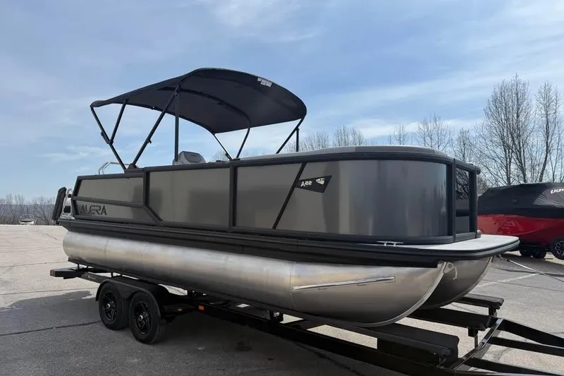 Slide: The Image of 2026 Alera 22l pontoon boat on trailer, featuring sleek design and canopy. - 1