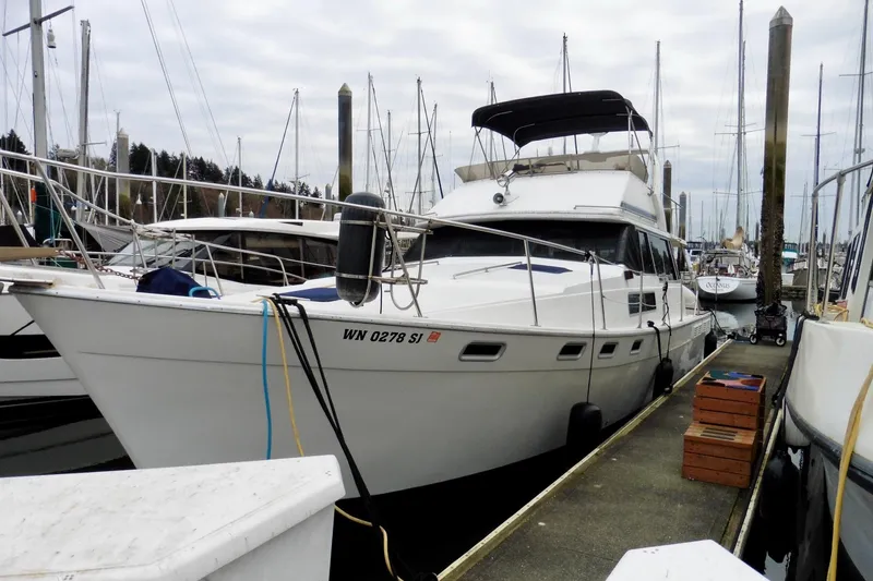 Slide: The Image of 1988 Bayliner 3888 Motoryacht docked at marina, surrounded by other boats. - 1