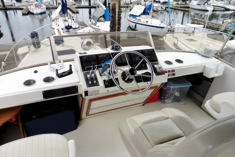 Slide: The Image of 1988 Bayliner 3888 Motoryacht helm with steering wheel and control panel at marina. - 15