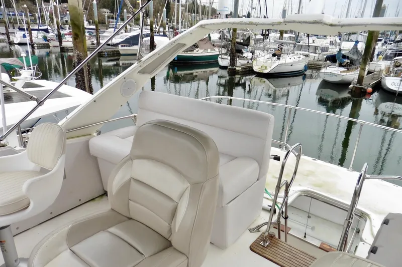 Slide: The Image of 1988 Bayliner 3888 Motoryacht interior with marina view, featuring white seating and helm. - 16