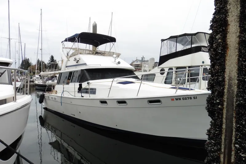 Slide: The Image of 1988 Bayliner 3888 Motoryacht docked at marina, surrounded by other boats. - 2