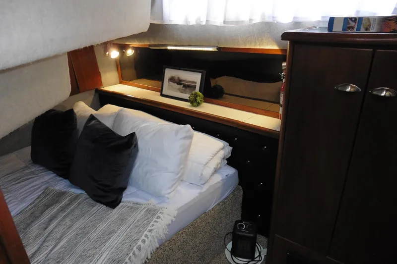 Slide: The Image of Cozy cabin interior of 1988 Bayliner 3888 Motoryacht with bed, pillows, and decor. - 29