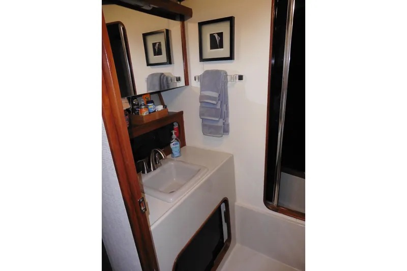 Slide: The Image of Bathroom interior of 1988 Bayliner 3888 Motoryacht with sink, mirror, and towels. - 30