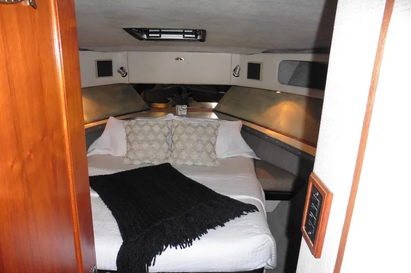 Slide: The Image of Cozy bedroom interior of 1988 Bayliner 3888 Motoryacht with elegant bedding and ambient lighting. - 31