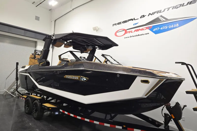 Slide: The Image of 2026 Nautique Super Air Nautique G25 Paragon boat on trailer in showroom. - 2
