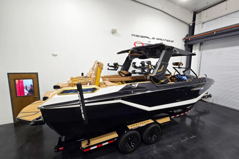 Slide: The Image of 2026 Nautique Super Air Nautique G25 Paragon boat in showroom, side view. - 3
