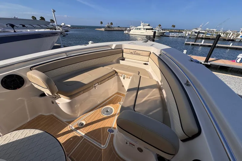 Slide: The Image of 2021 Sea Chaser 22 HFC boat interior with tan seating and wood flooring at a marina. - 15