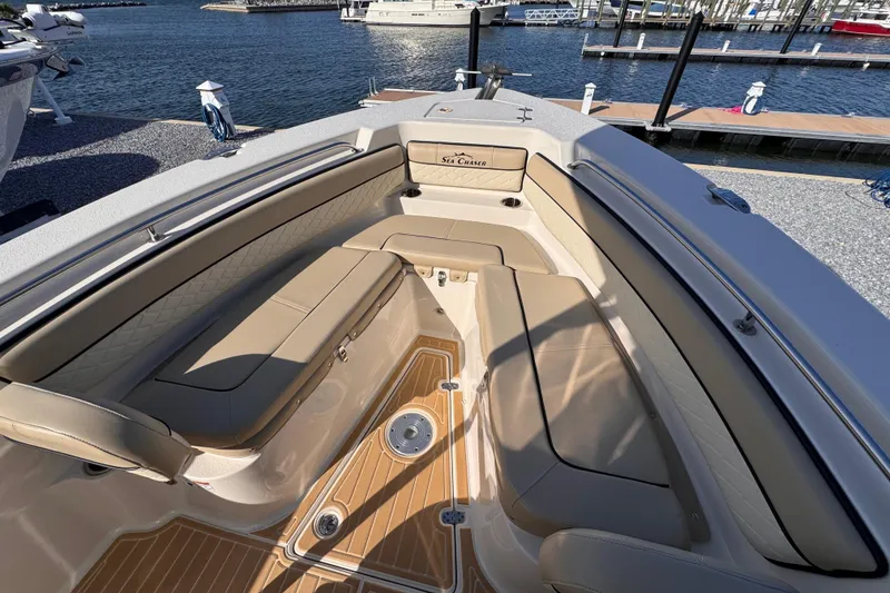 Slide: The Image of 2021 Sea Chaser 22 HFC boat interior with tan seating and wood-style flooring at a marina. - 16