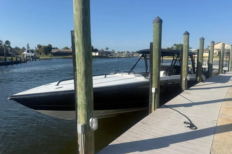The Image of 2009 Nor-Tech 4400 Roadster docked by a sunny waterfront pier. - 1