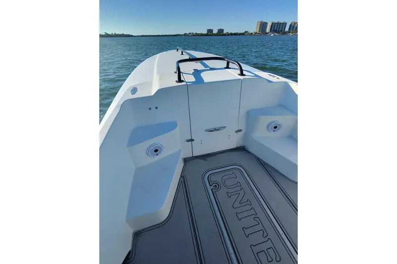 Slide: The Image of 2009 Nor-Tech 4400 Roadster boat interior with seating, on calm water, city skyline in background. - 23
