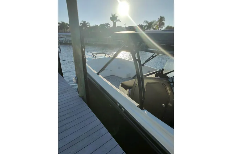 Slide: The Image of 2009 Nor-Tech 4400 Roadster docked by a sunny waterfront with palm trees. - 3