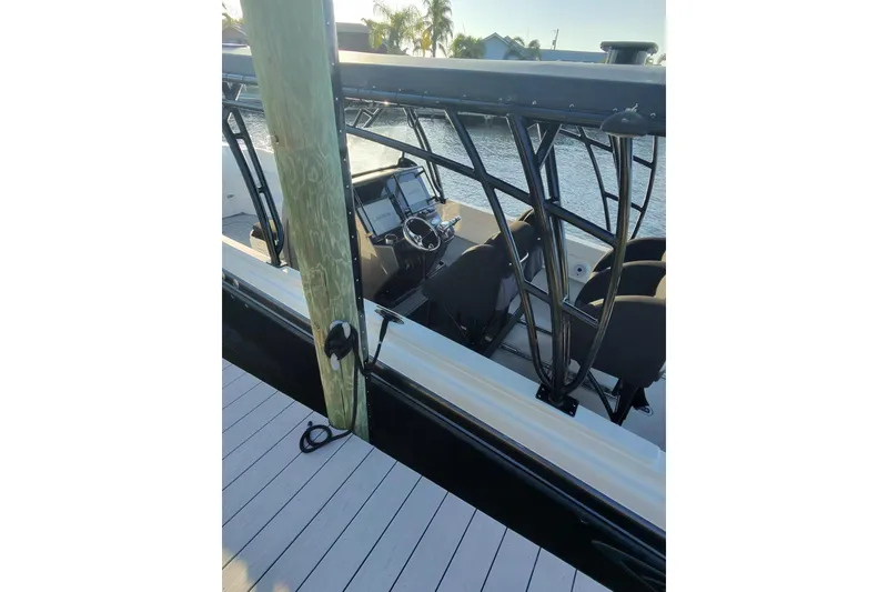 Slide: The Image of 2009 Nor-Tech 4400 Roadster boat docked, showcasing helm and seating area. - 4