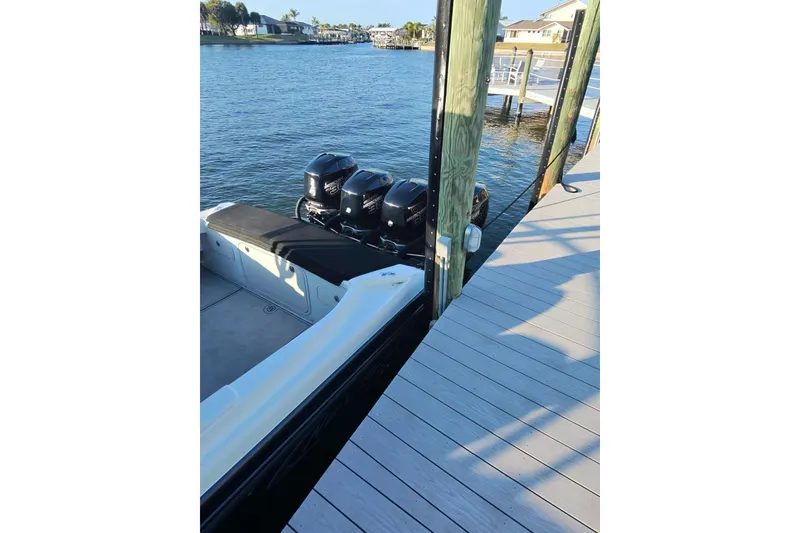 Slide: The Image of 2009 Nor-Tech 4400 Roadster docked by a wooden pier with triple engines. - 5