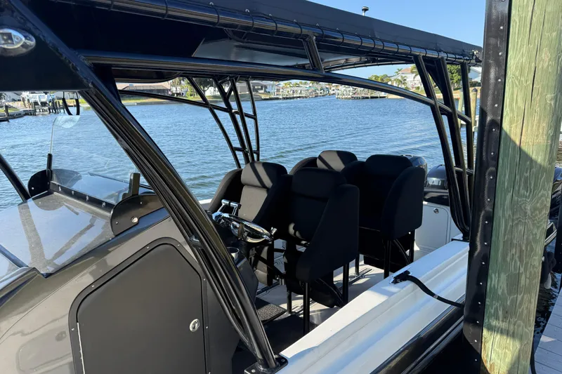 Slide: The Image of 2009 Nor-Tech 4400 Roadster boat interior with seating, docked by the water. - 7