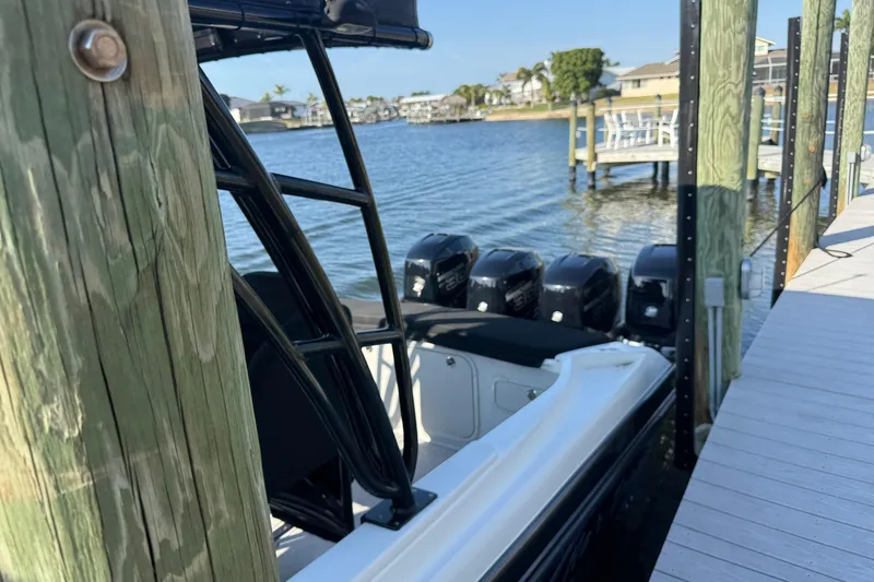 Slide: The Image of 2009 Nor-Tech 4400 Roadster docked by a wooden pier with multiple outboard engines. - 8