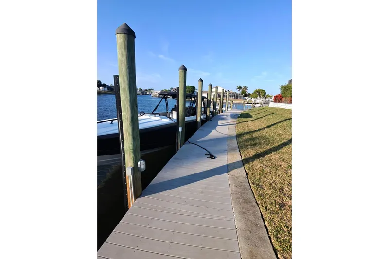 Slide: The Image of Docked 2009 Nor-Tech 4400 Roadster boat beside a wooden pier on a sunny day. - 9