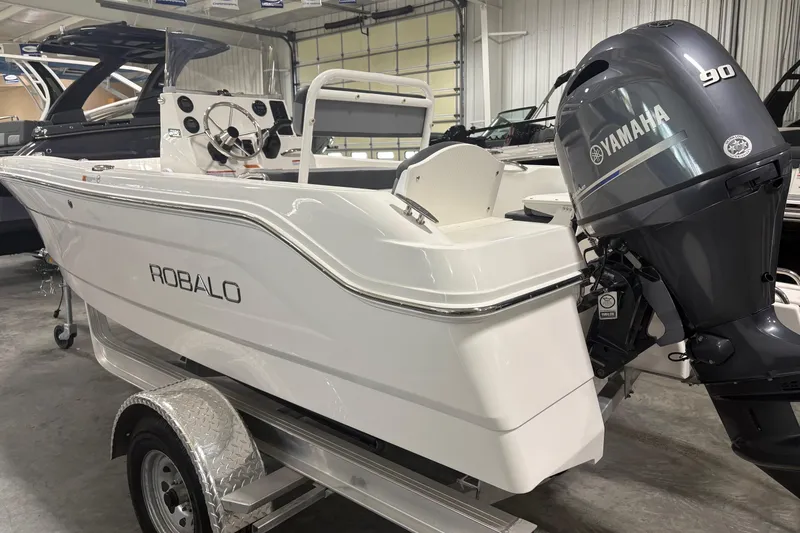 Slide: The Image of 2026 Robalo R160 Center Console boat with Yamaha 90 engine in showroom. - 2