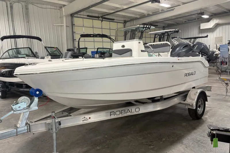 Slide: The Image of 2026 Robalo R160 Center Console boat on trailer in indoor showroom. - 3