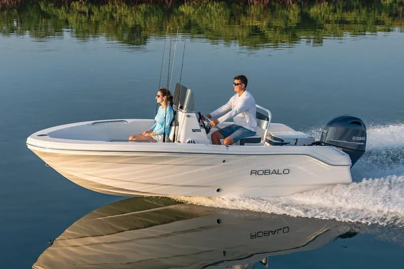 Slide: The Image of Manufacturer Provided Image: 2026 Robalo R160 Center Console boat cruising on calm water with two passengers. - 8