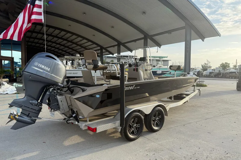 The Image of 2022 Excel 203 Bay Pro boat with Yamaha engine on trailer, under a canopy. - 1