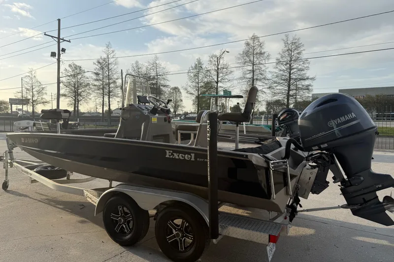 Slide: The Image of 2022 Excel 203 Bay Pro boat with Yamaha motor on trailer, parked outdoors. - 3