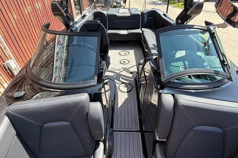 Slide: The Image of 2023 MasterCraft XStar S Piranha boat interior with sleek black seating and modern design. - 14