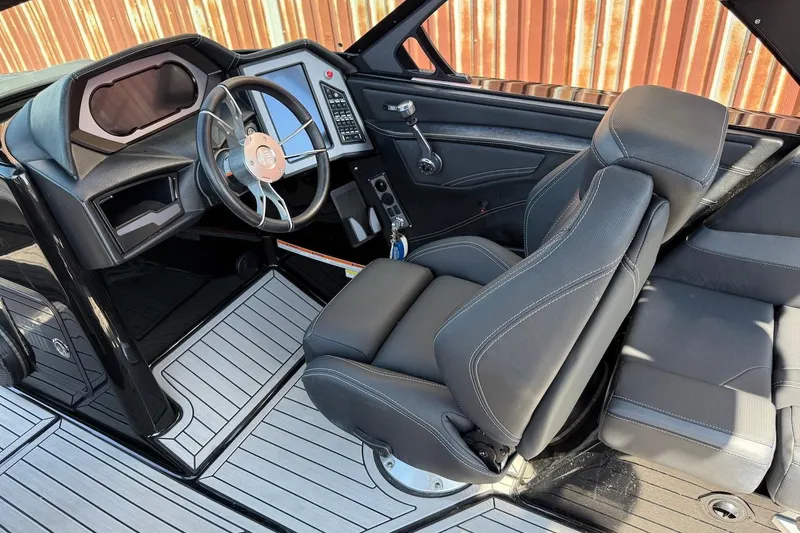 Slide: The Image of 2023 MasterCraft XStar S Piranha cockpit with sleek black seating and modern dashboard design. - 6