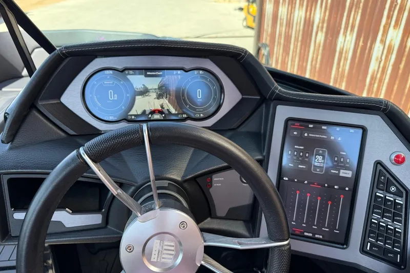 Slide: The Image of 2023 MasterCraft XStar S Piranha dashboard with digital displays and control panel. - 7