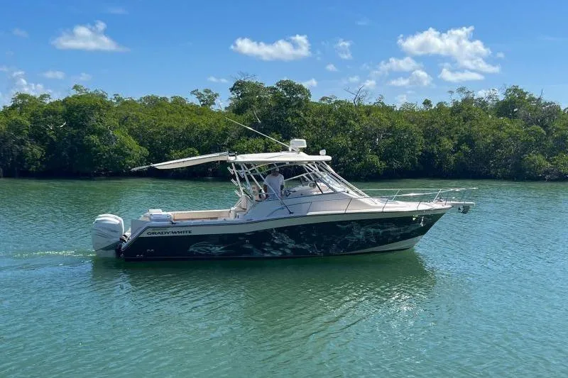The Image of 2006 Grady-White Express 330 boat cruising on a calm, scenic waterway. - 0