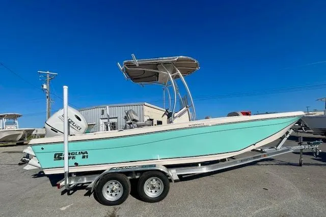 The Image of 2026 Carolina Skiff 21 Ultra Elite boat on trailer, side view, clear blue sky. - 1