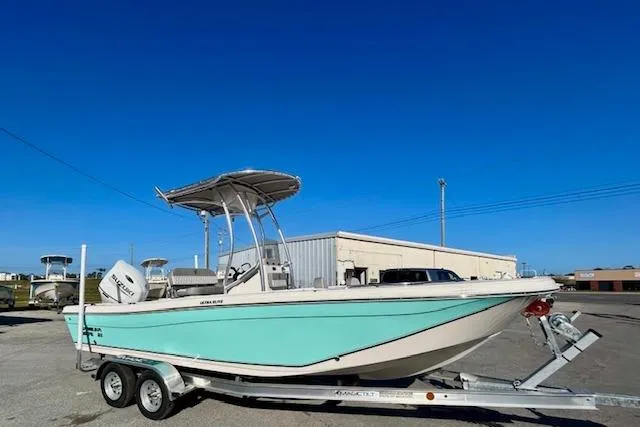 Slide: The Image of 2026 Carolina Skiff 21 Ultra Elite boat on trailer, light blue hull, sunny day. - 2