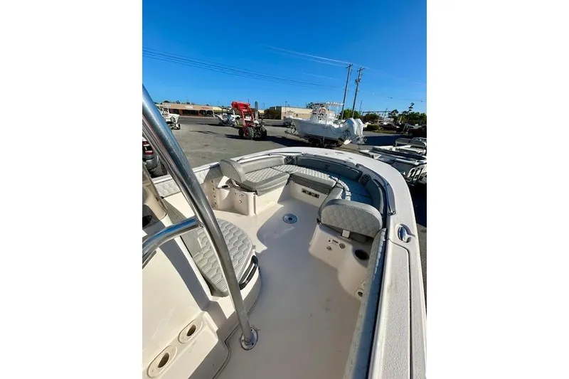Slide: The Image of 2026 Carolina Skiff 21 Ultra Elite boat interior with seating and storage, parked outdoors. - 8