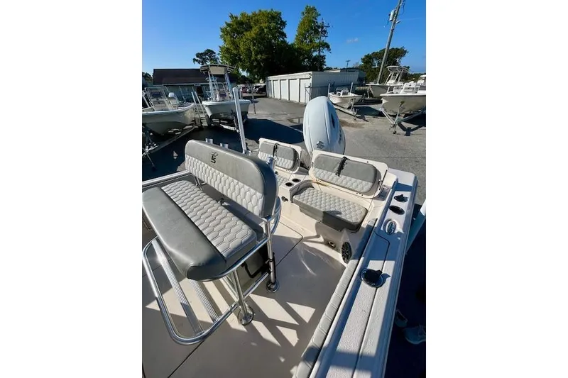 Slide: The Image of 2026 Carolina Skiff 21 Ultra Elite boat interior with seating and console, parked outdoors. - 9