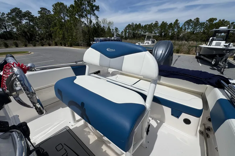 Slide: The Image of 2023 Robalo R202 Explorer boat interior with blue and white seating, steering wheel, and outboard motor. - 14