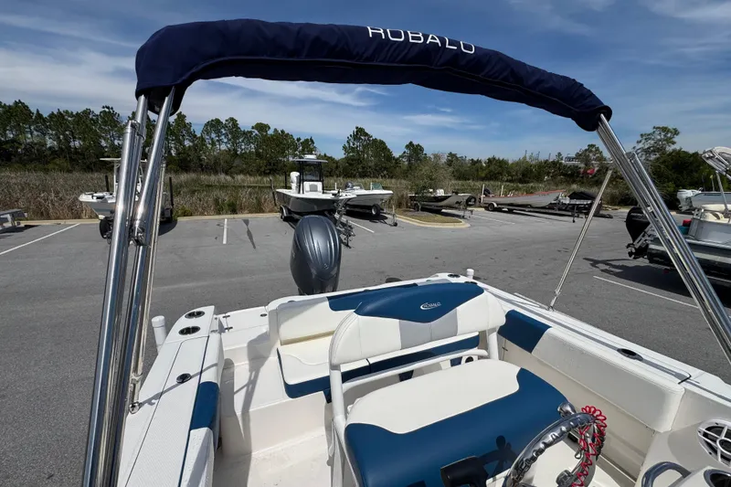 Slide: The Image of 2023 Robalo R202 Explorer boat interior with blue and white seating in a parking lot. - 15