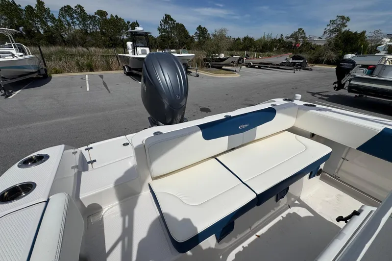Slide: The Image of 2023 Robalo R202 Explorer boat with seating and outboard motor in parking lot. - 16