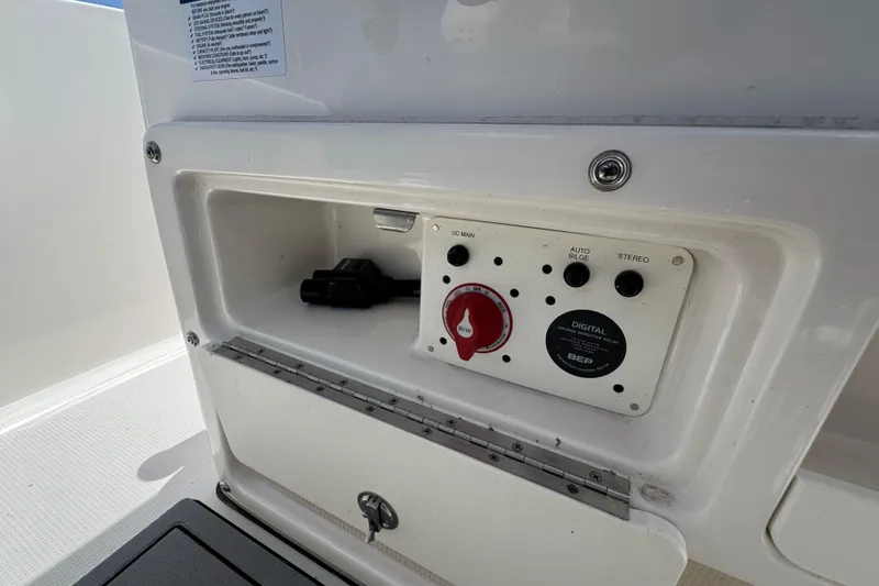 Slide: The Image of 2023 Robalo R202 Explorer control panel with switches and storage compartment. - 19